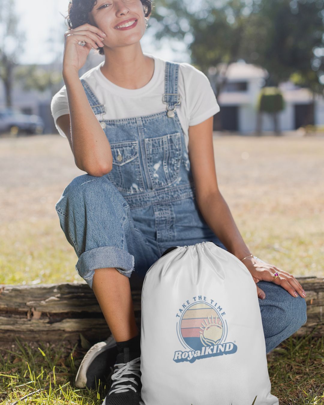 Person sitting outdoors with a Royal Kind bag